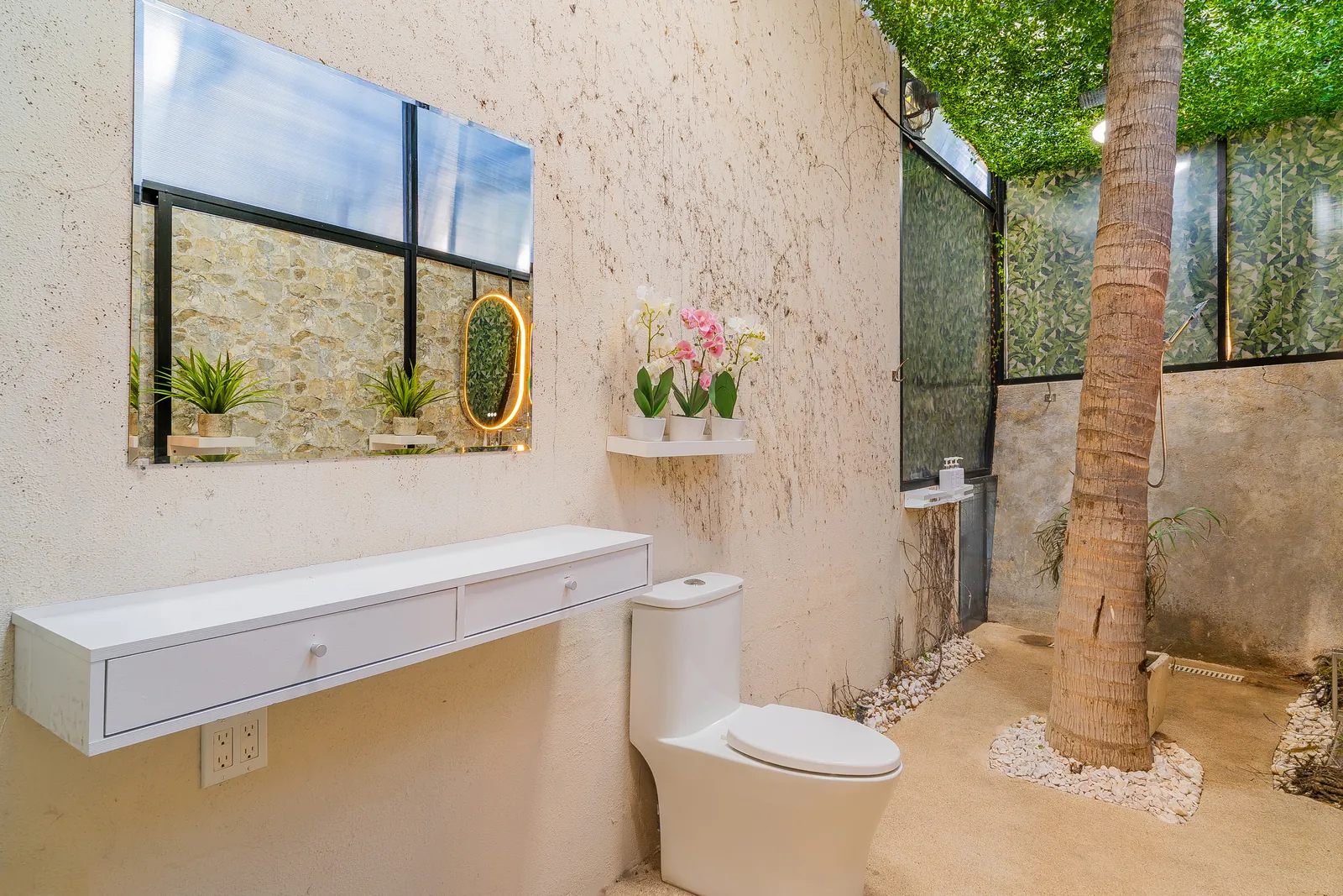 Open-air rainforest shower with palm